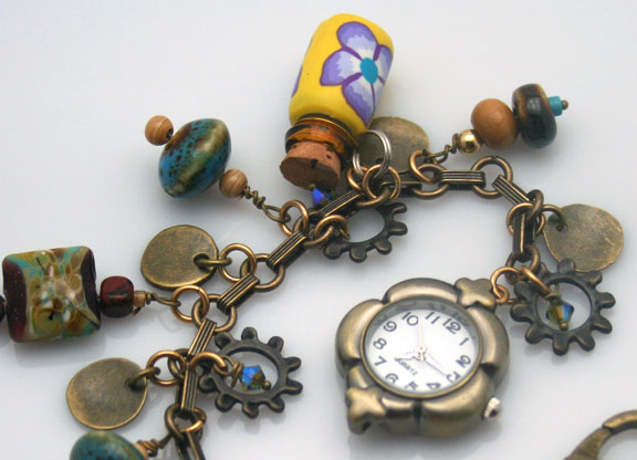 close-up of the watch, beads, and aromatherapy bottle