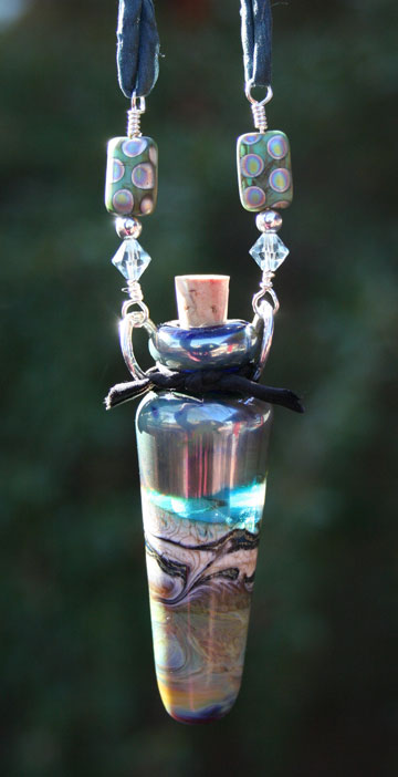 glass aromatherapy vessel necklace hanging in the sunlight