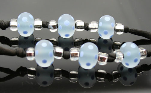 close-up of the periwinkle, polkadot glass beads that adorn this aromatherapy necklace