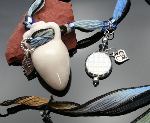 view of silver charms and peacock bead