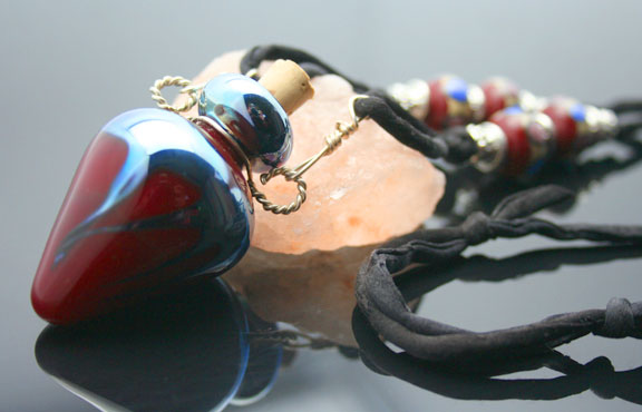 Deep red with metallic blue swirls in this aromatherapy pendant