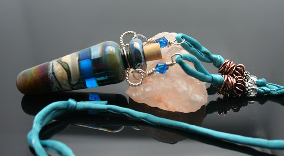 Earth, sand, waves and blue sky are imagined in this glass aromatherapy pendant