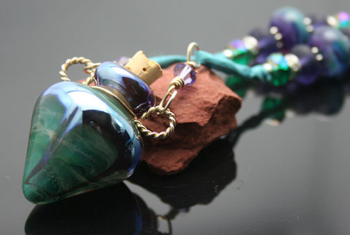 orgeous swirls of teal green, purples, and silver in this aromatherapy bottle necklace