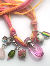 aromatherapy jewelry with glass bottle, silk cord, and charms