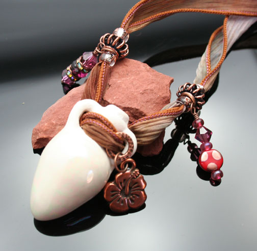 aromatherapy jewelry with a clay amphora pendant, silk ribbon, beads, crystals and charms